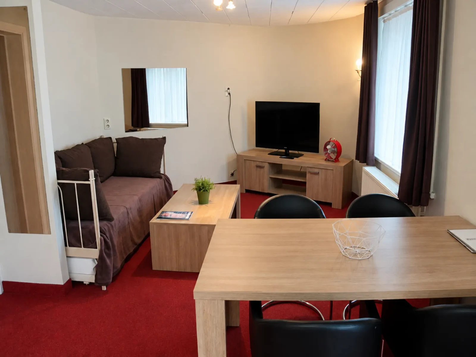 Woon- en eethoek van het appartement met bank en televisie